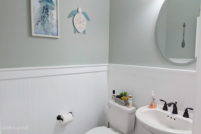 502 Vanderhorst Ave, Shallotte, NC 28470 - half bathroom featuring toilet, a sink, and wainscoting