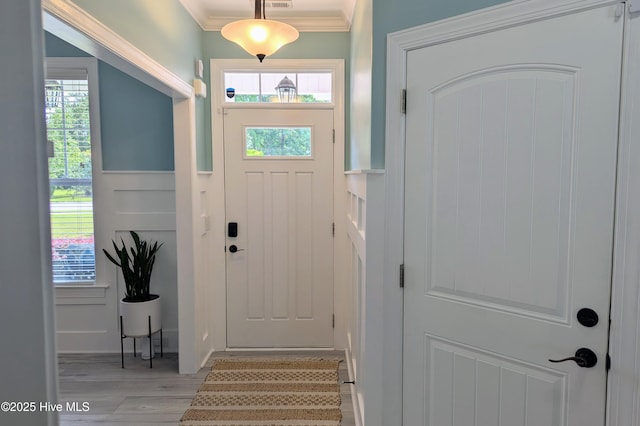 502 Vanderhorst Ave, Shallotte, NC 28470 - foyer entrance with crown molding, light wood-style floors, wainscoting, a decorative wall, and stairway