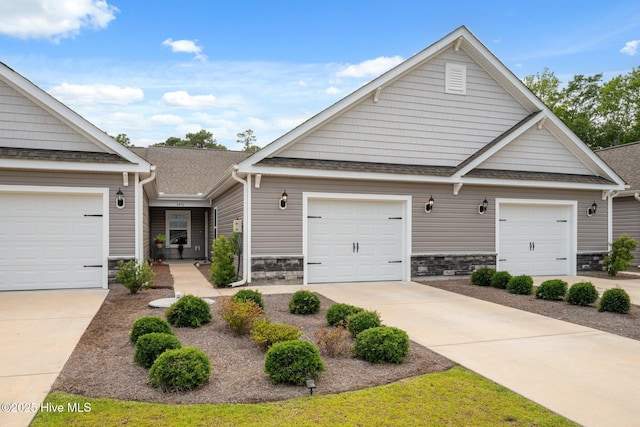6476 Merceron St Unit 2B, Ocean Isle Beach, NC 28469 - view of front of property with stone siding, a shingled roof, driveway, and a garage
