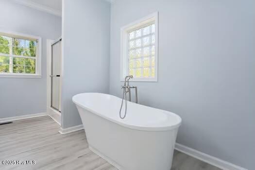 225 Factory Rd, Hampstead, NC 28443 - bathroom featuring a soaking tub, wood finished floors, baseboards, and a shower with shower door