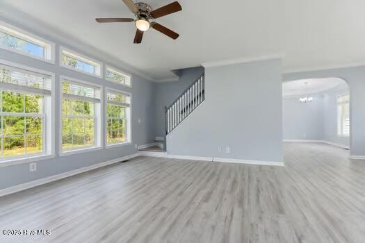 225 Factory Rd, Hampstead, NC 28443 - unfurnished living room with baseboards, wood finished floors, a ceiling fan, arched walkways, and stairs