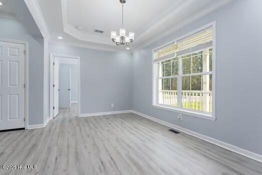 225 Factory Rd, Hampstead, NC 28443 - unfurnished room with wood finished floors, a chandelier, a tray ceiling, baseboards, and ornamental molding