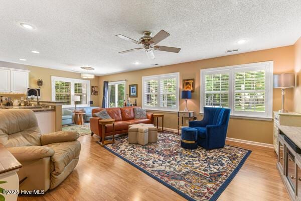 1135 Sunburst Way, Leland, NC 28451 - living room with a textured ceiling, light wood-style floors, baseboards, a ceiling fan, and recessed lighting