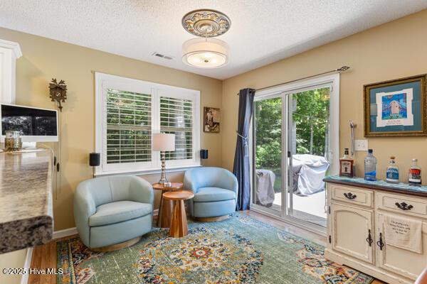 1135 Sunburst Way, Leland, NC 28451 - sitting room featuring a textured ceiling, wood finished floors, and baseboards