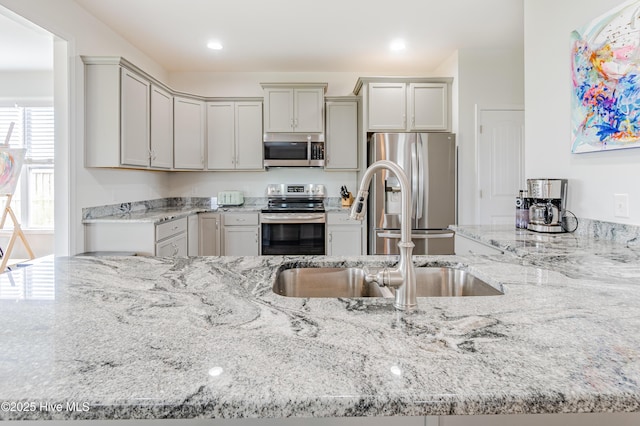 522 Heartwood Dr, Leland, NC 28479 - kitchen with appliances with stainless steel finishes, a sink, light stone counters, recessed lighting, and gray cabinetry