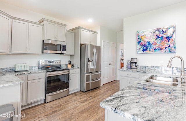 522 Heartwood Dr, Leland, NC 28479 - kitchen with appliances with stainless steel finishes, a sink, light wood-style floors, light stone countertops, and recessed lighting