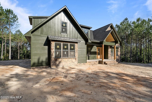 445 Oldham Rd, West End, NC 27376 - view of front of property featuring covered porch, stone siding, board and batten siding, a standing seam roof, and a metal roof