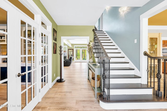 414 Yaupon Dr, Southport, NC 28461 - stairway with french doors, wood finished floors, and baseboards