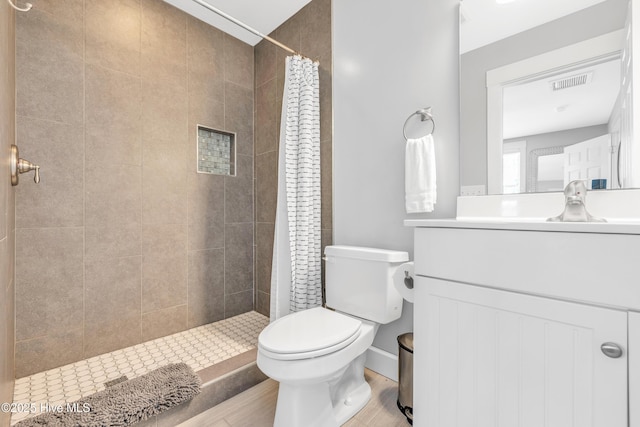 414 Yaupon Dr, Southport, NC 28461 - full bath featuring toilet, vanity, a tile shower, and wood finished floors