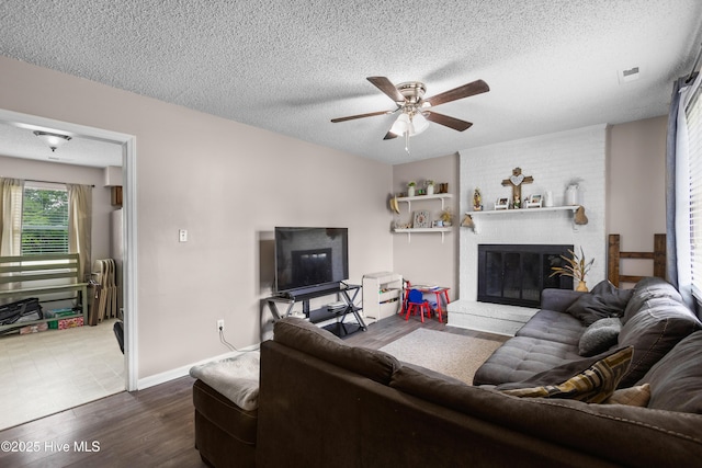 453 Hunting Green Dr, Jacksonville, NC 28546 - living room with ceiling fan, dark wood-type flooring, a textured ceiling, and a brick fireplace