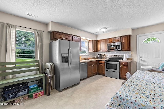453 Hunting Green Dr, Jacksonville, NC 28546 - kitchen featuring stainless steel appliances, healthy amount of natural light, light floors, and a textured ceiling