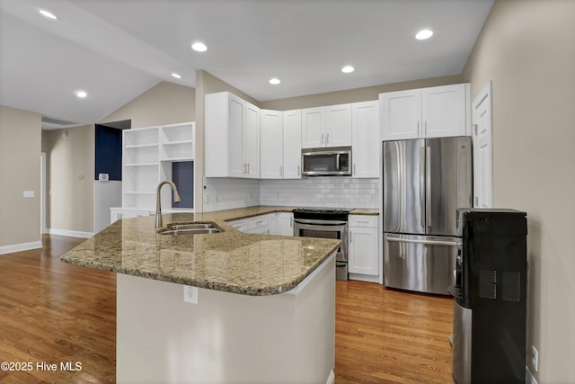 5622 Shell Road Village Dr, Wilmington, NC 28403 - kitchen with appliances with stainless steel finishes, a sink, a peninsula, light stone countertops, and white cabinetry