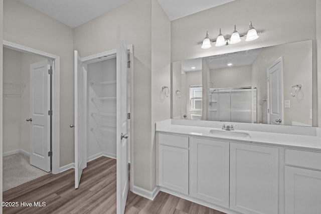 1008 Rodanthe Dr, New Bern, NC 28562 - bathroom with a spacious closet, a stall shower, vanity, wood finished floors, and baseboards