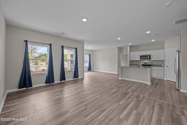 1008 Rodanthe Dr, New Bern, NC 28562 - unfurnished living room with baseboards, light wood-type flooring, and recessed lighting