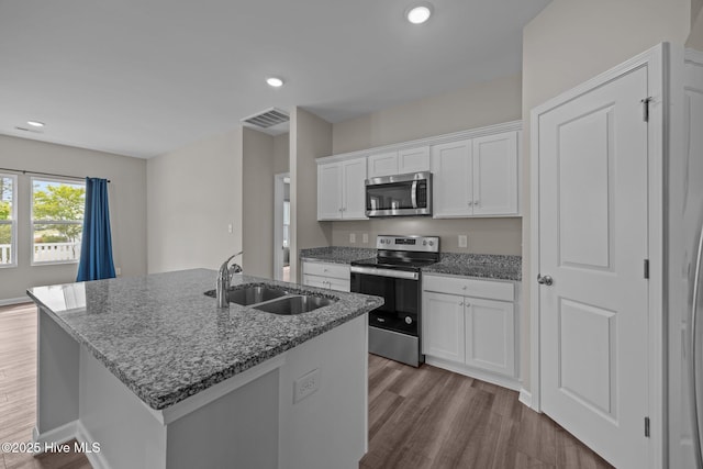 1008 Rodanthe Dr, New Bern, NC 28562 - kitchen with appliances with stainless steel finishes, a sink, wood finished floors, a center island with sink, and white cabinetry