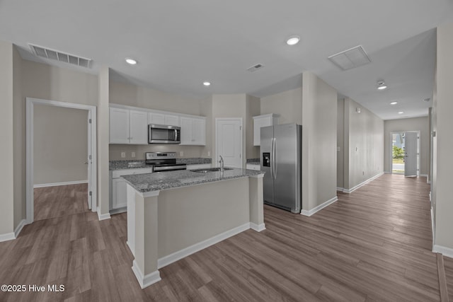 1008 Rodanthe Dr, New Bern, NC 28562 - kitchen featuring appliances with stainless steel finishes, a sink, white cabinetry, a center island with sink, and wood finished floors
