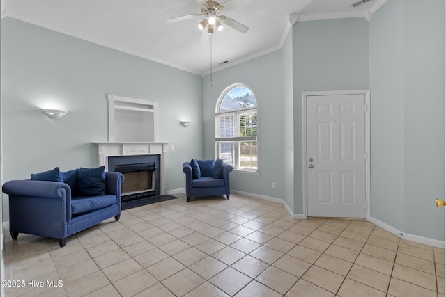 1001 Windgate Dr, Wilmington, NC 28412 - living room featuring light tile patterned flooring, a fireplace, a ceiling fan, ornamental molding, and high vaulted ceiling