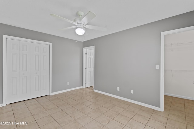 1001 Windgate Dr, Wilmington, NC 28412 - unfurnished bedroom with a walk in closet, ceiling fan, light tile patterned floors, and baseboards