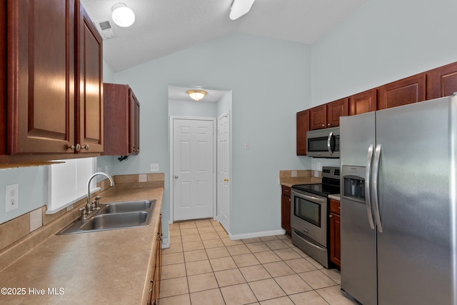 1001 Windgate Dr, Wilmington, NC 28412 - kitchen with appliances with stainless steel finishes, a sink, lofted ceiling, light countertops, and light tile patterned floors