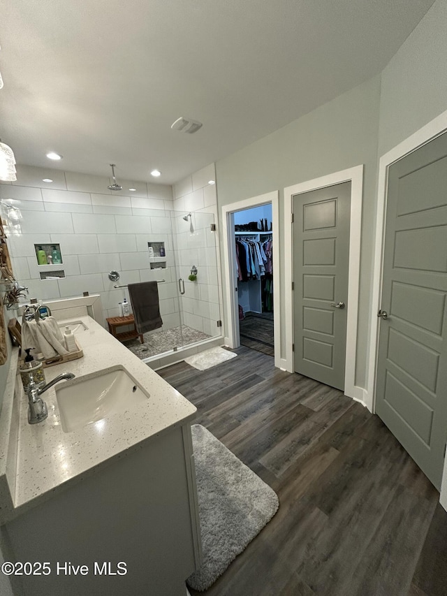 429 Island Creek Rd, Rocky Point, NC 28457 - bathroom with a shower stall, wood finished floors, double vanity, a spacious closet, and recessed lighting
