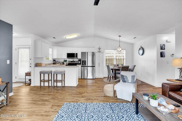 222 Bridgeton Ct, Wilmington, NC 28411 - living area with vaulted ceiling, light wood-style floors, and baseboards