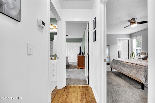 222 Bridgeton Ct, Wilmington, NC 28411 - bedroom featuring light wood finished floors, baseboards, a ceiling fan, connected bathroom, and a textured ceiling