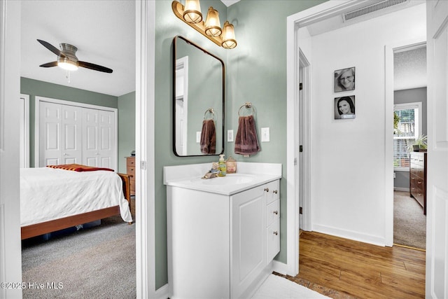 222 Bridgeton Ct, Wilmington, NC 28411 - bathroom featuring vanity, connected bathroom, ceiling fan, baseboards, and wood finished floors
