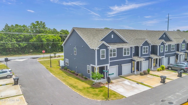 6751 Blacktip Ln, Wilmington, NC 28412 - view of front of property featuring an attached garage, a shingled roof, driveway, and a front lawn