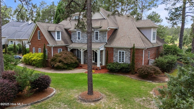 30 Spring Valley Ct, Pinehurst, NC 28374 - shingle-style home with a front yard, a shingled roof, brick siding, and stone siding