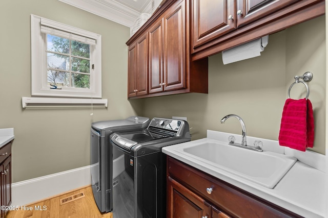 30 Spring Valley Ct, Pinehurst, NC 28374 - washroom featuring cabinet space, independent washer and dryer, ornamental molding, and light wood-style flooring