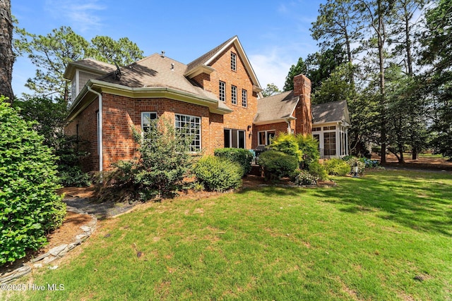 30 Spring Valley Ct, Pinehurst, NC 28374 - rear view of property featuring brick siding, a yard, a chimney, and a shingled roof