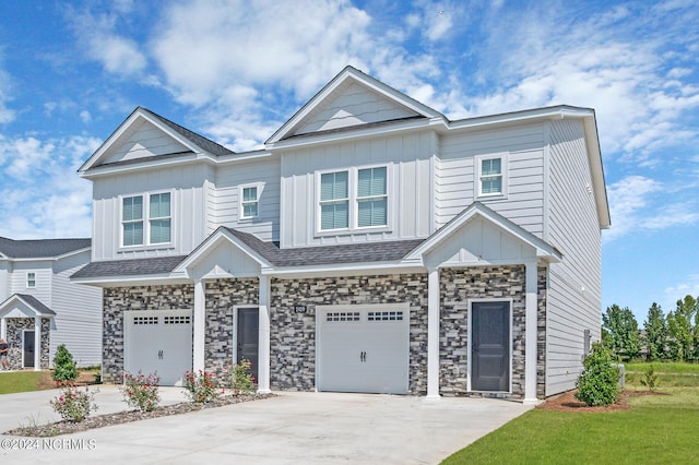 2125 Kali Ln Unit B, Greenville, NC 27834 - view of front facade featuring board and batten siding, a garage, driveway, stone siding, and a shingled roof
