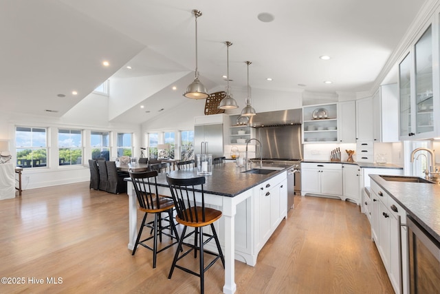 585 Forest Dunes Dr, Pine Knoll Shores, NC 28512 - kitchen featuring open shelves, wall chimney exhaust hood, plenty of natural light, light wood-style flooring, and high vaulted ceiling