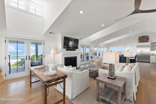 585 Forest Dunes Dr, Pine Knoll Shores, NC 28512 - living room with high vaulted ceiling, recessed lighting, a large fireplace, healthy amount of natural light, and light wood-style floors