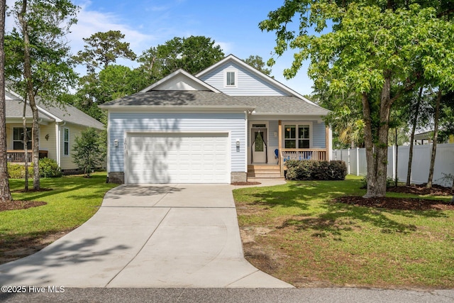 163 NE 31st St, Oak Island, NC 28465 - traditional-style home with covered porch, concrete driveway, an attached garage, and a shingled roof