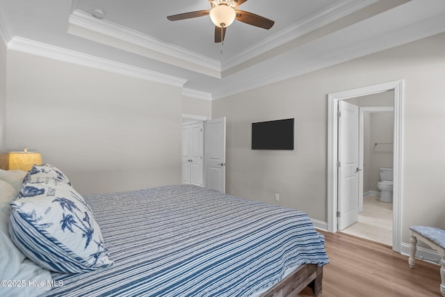 163 NE 31st St, Oak Island, NC 28465 - bedroom with a tray ceiling, light wood finished floors, crown molding, baseboards, and ensuite bath
