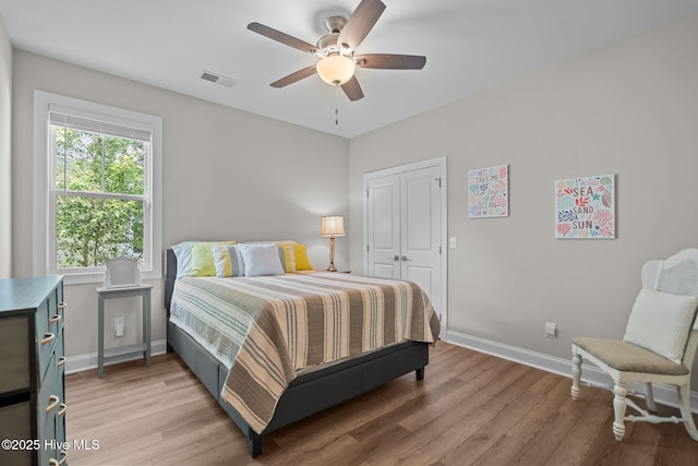 163 NE 31st St, Oak Island, NC 28465 - bedroom featuring light wood-style floors, baseboards, a closet, and a ceiling fan
