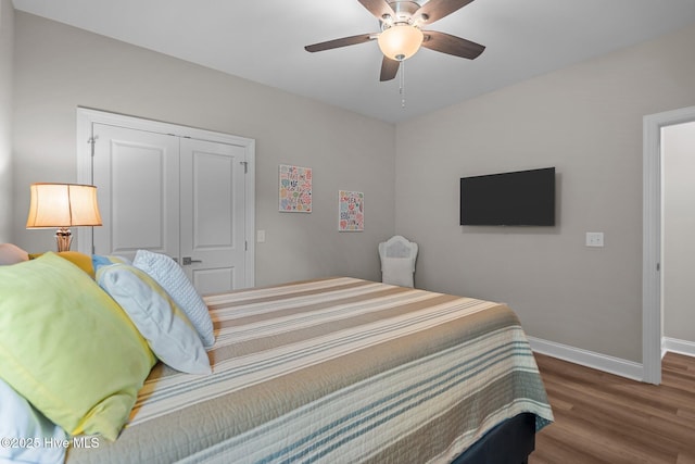 163 NE 31st St, Oak Island, NC 28465 - bedroom featuring baseboards, wood finished floors, a closet, and ceiling fan
