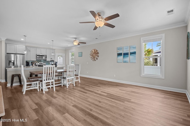 163 NE 31st St, Oak Island, NC 28465 - dining room with baseboards, crown molding, light wood-style flooring, a ceiling fan, and recessed lighting