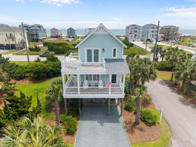 102 Seaside Ln, North Topsail Beach, NC 28460 - coastal inspired home featuring a balcony, gravel driveway, and a carport