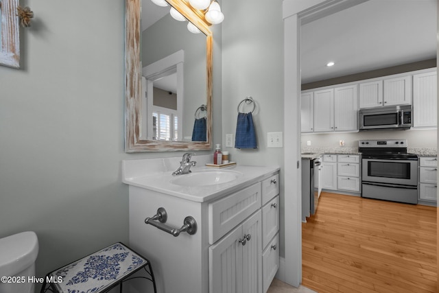 102 Seaside Ln, North Topsail Beach, NC 28460 - bathroom with vanity, recessed lighting, and wood finished floors