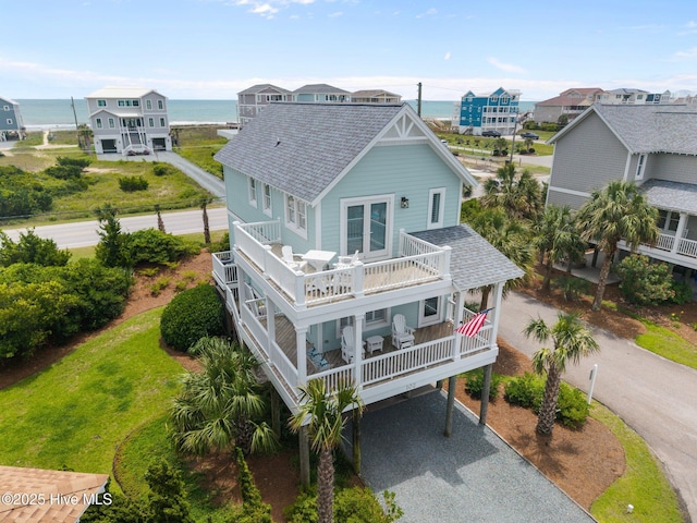 102 Seaside Ln, North Topsail Beach, NC 28460 - rear view of property with roof with shingles, driveway, a balcony, a water view, and a carport