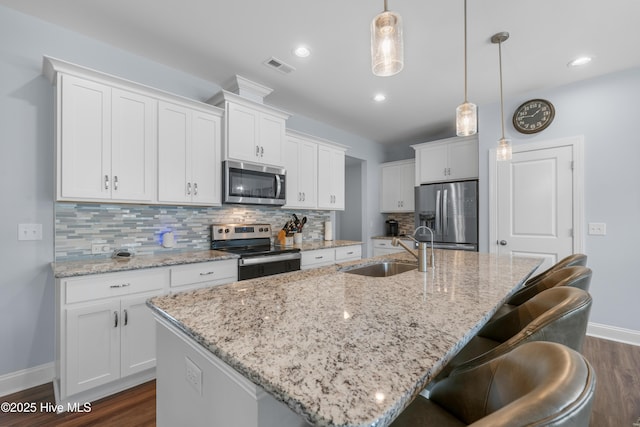 74 W Weatherbee Way, Hampstead, NC 28443 - kitchen with stainless steel appliances, a sink, baseboards, dark wood finished floors, and decorative backsplash