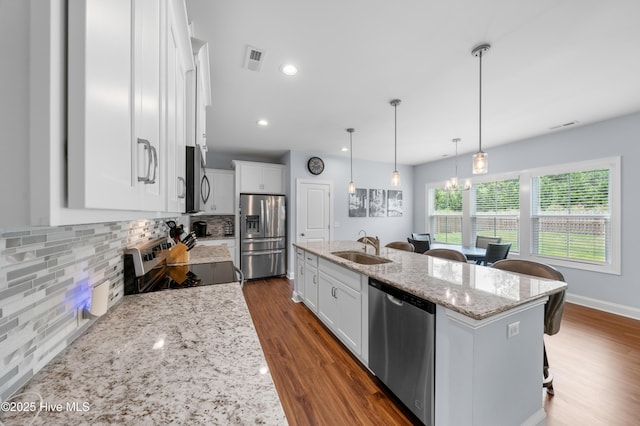 74 W Weatherbee Way, Hampstead, NC 28443 - kitchen with appliances with stainless steel finishes, a sink, decorative backsplash, white cabinets, and light stone countertops