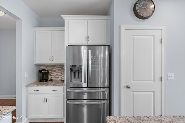 74 W Weatherbee Way, Hampstead, NC 28443 - kitchen featuring stainless steel fridge, tasteful backsplash, white cabinets, and light stone countertops