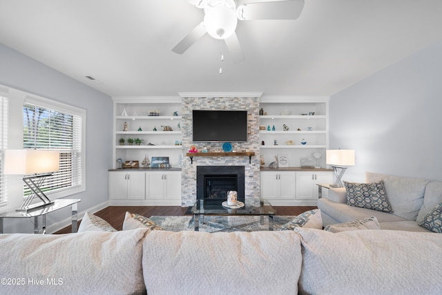 74 W Weatherbee Way, Hampstead, NC 28443 - living area with dark wood-type flooring, ceiling fan, a stone fireplace, baseboards, and built in features