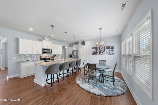 74 W Weatherbee Way, Hampstead, NC 28443 - dining space featuring dark wood finished floors, a chandelier, baseboards, and recessed lighting