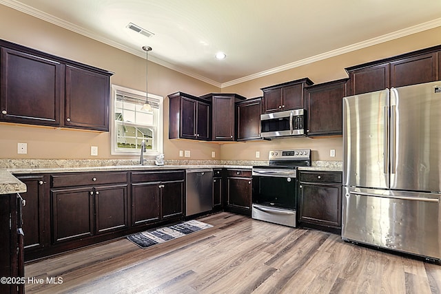 514 Everett Glades, Sneads Ferry, NC 28460 - kitchen featuring appliances with stainless steel finishes, light wood-type flooring, dark brown cabinetry, crown molding, and hanging light fixtures