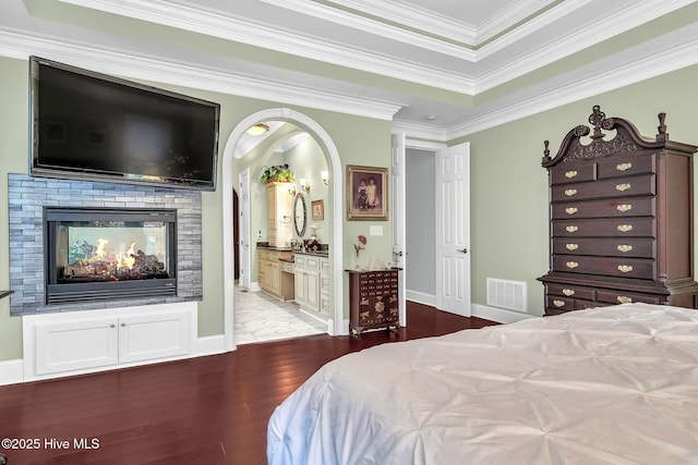249 Maple Creek Dr, Wallace, NC 28466 - bedroom featuring wood finished floors, crown molding, arched walkways, and ensuite bathroom
