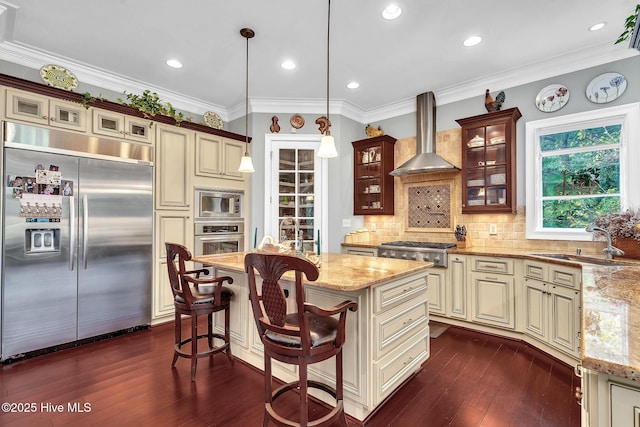 249 Maple Creek Dr, Wallace, NC 28466 - kitchen featuring built in appliances, cream cabinetry, wall chimney range hood, light stone counters, and ornamental molding